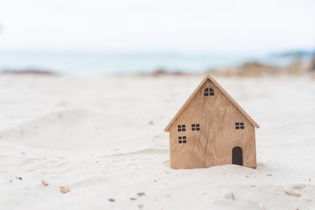 Miniature wooden house on the beach background